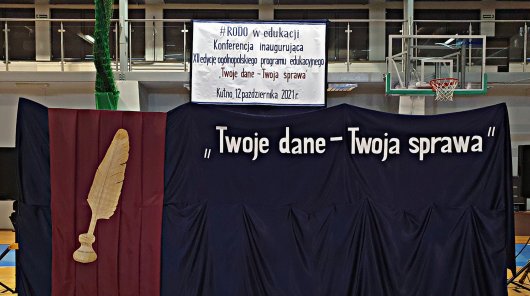 Zdjęcie przedstawia płachtę w kolorze granatowym, przepasaną bordowym suknem z wizerunkiem pióra w kałamarzu, z napisem "Twoje dane - Twoja sprawa".