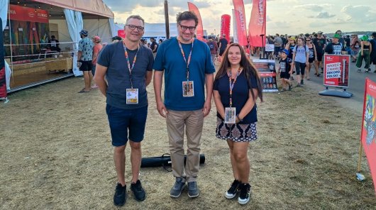 Zdjęcie przedstawiające Mirosława Wróblewskiego, prezesa UODO (w środku), po prawej stronie od prezesa - Izabela Maryańska, pracownik Infolinii UODO, po lewej Tomasz Ochmiński, dyrektor Departamentu Nowych Technologii przed sceną podczas Pol’and’Rock Festiwal.