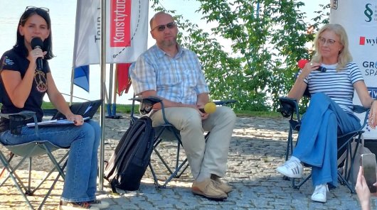 Zdjęcie przedstawiające Romana Sobotkę (siedzącego na krześle w środku), pracownika UODO, po jego prawej stronie siedząca na krześle - Monika Maćkowiak, sędzia Sądu Rejonowego w Bydgoszczy, po lewej stronie siedząca na krześle moderatorka debaty Tour de Konstytucja.