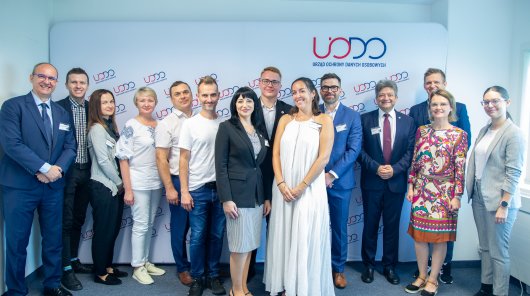 Zdjęcie grupowe uczestników wydarzenia na tle rollapu z logo UODO 