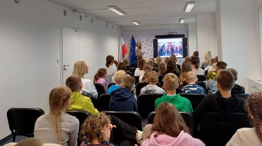 Zdjęcie przedstawiające Elżbietę Świątek pracownika Departamentu Współpracy Międzynarodowej i Edukacji UODO - prowadząca lekcję edukacyjną w ramach edycji programu „Lekcje o finansach”. 