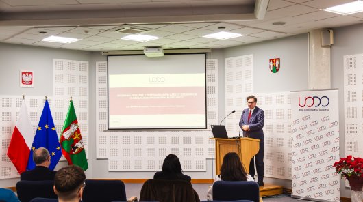 Zdjęcie przedstawia przemawiającego Prezesa UODO oraz słuchające go zgromadzone osoby